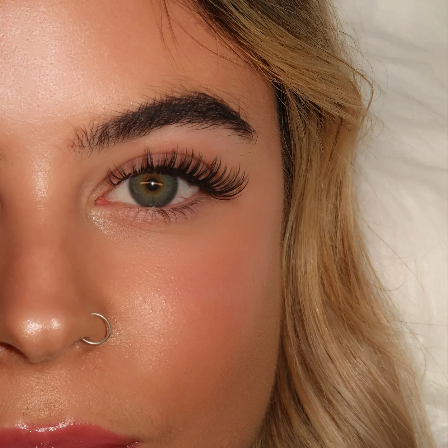 Single green eye with volume lashes, nose ring, blonde, white fur